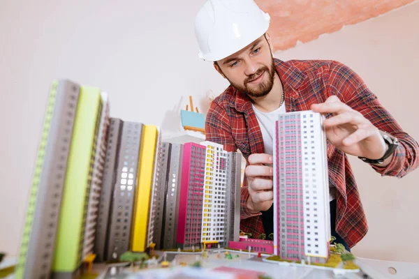 Retrato de un joven ingeniero que trata con un modelo de construcción complejo —  Fotos de Stock