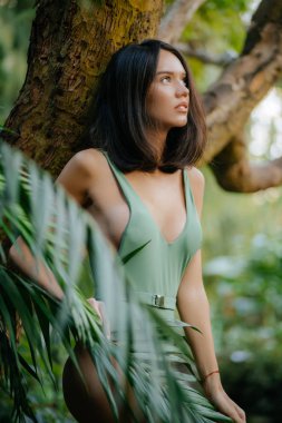 sensual young brunette lovely woman in tropical jungle