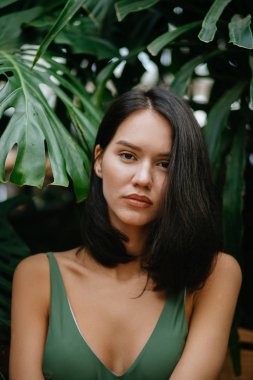 young beautiful model around green fresh plants