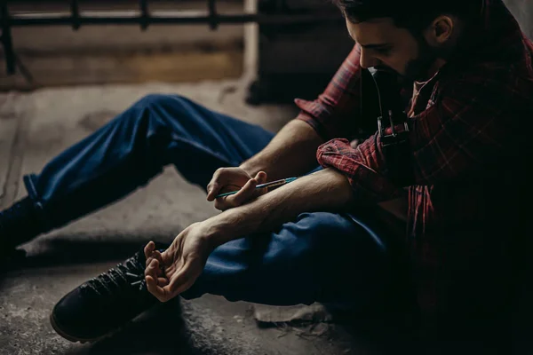 young drug user injecting heroin into veins