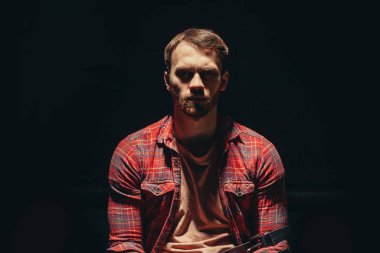 portrait of young caucasian junkie man sitting in the dark