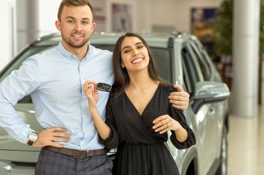 new owners of beautiful car in showroom