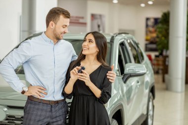 happy couple get new automobile in dealership