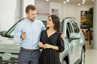 happy couple get new automobile in dealership
