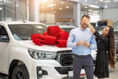 positive smiling lady make surprise to man, in dealership
