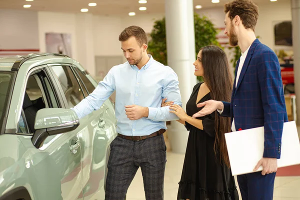 Couple choosing new auto in dealership — Stockfoto