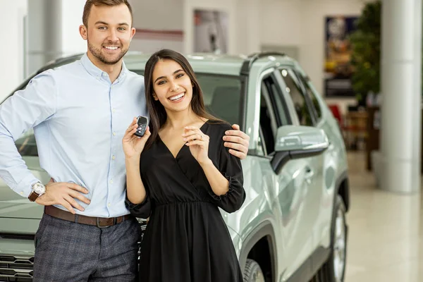 Novos proprietários de automóveis posando em concessionária — Fotografia de Stock