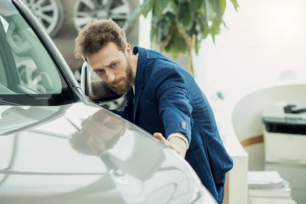 Jovem cara acariciando um novo carro — Fotografia de Stock