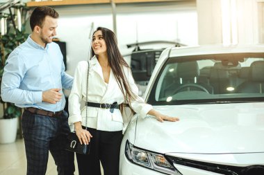 handsome guy and beautiful woman choosing car