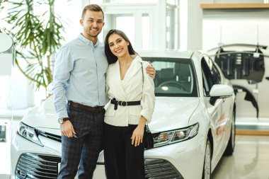 portrait of married couple in car showroom