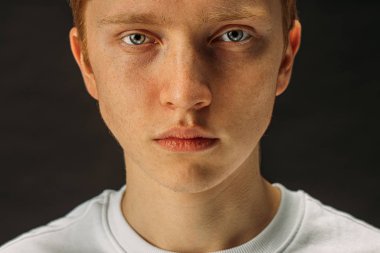 close-up face of redhaired boy looking at camera