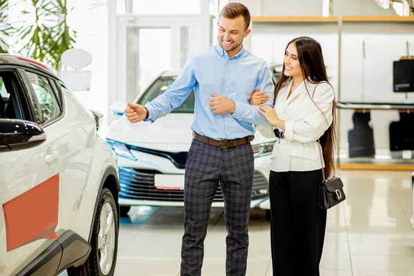 Homem mostrar novo automóvel para a esposa, ele quer comprá-lo — Fotografia de Stock