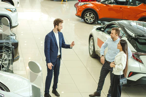 Feliz pareja positiva en busca de hermoso coche nuevo — Foto de Stock