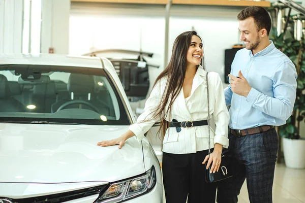 Happy couple get new automobile in dealership — Stockfoto