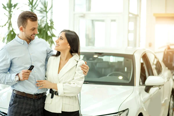 New owners of beautiful car in showroom — Stockfoto