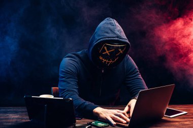 criminal man hides his face under the hood and mask