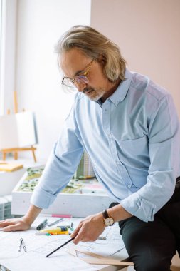 Ofiste çalışan olgun mimar ya da mühendis.