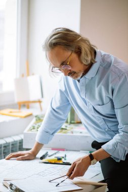 senior man architect studying drawings