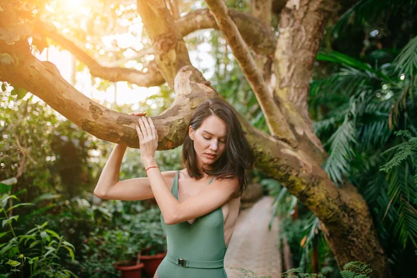 Чарівна приваблива брюнетка леді позує в ботанічному саду з рослинами — стокове фото