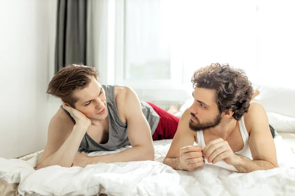 Glückliches gleichgeschlechtliches homosexuelles Paar, das Ruhe auf dem Bett nimmt — Stockfoto