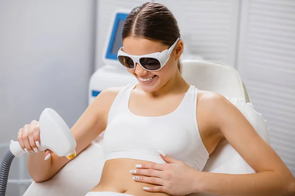 Mujer feliz haciendo procedimiento de depilación con el equipo por sí misma — Foto de Stock