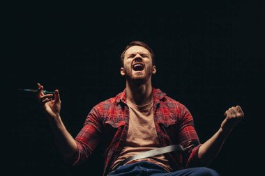 Bağıran uyuşturucu kullanıcısı siyah arkaplanda izole edildi