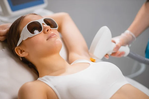 Young lady getting laser epilation procedure on armpits — Stock Photo, Image