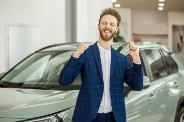 Neşeli komik adam yeni arabasından anahtar aldığı için mutlu.