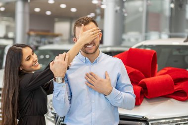 attractive lady going to give new car as a gift to man