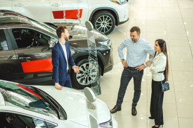happy positive couple looking for beautiful new car