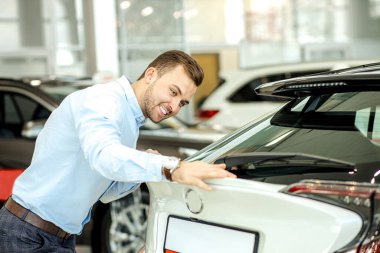 gülümseyen Kafkas alıcı yeni otomotiv yüzeyini inceliyor, kontrol ediyor