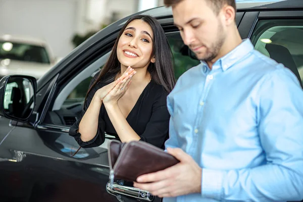 Legrační žena prosí svého přítele koupit nové auto — Stock fotografie