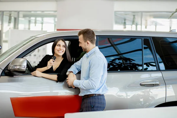 Belo casal comprou carro novo na concessionária — Fotografia de Stock