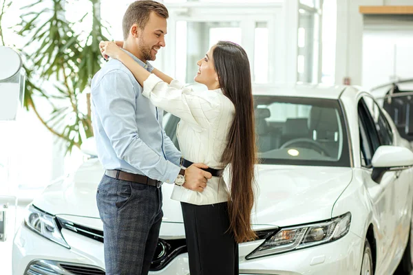 Belo casal comprar carro novo na concessionária — Fotografia de Stock