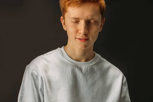 Ung rödhårig pojke med slutna ögon isolerad — Stockfoto