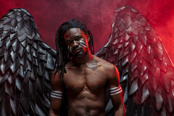 без рубашки темный ангел в красном дымчатом пространстве
