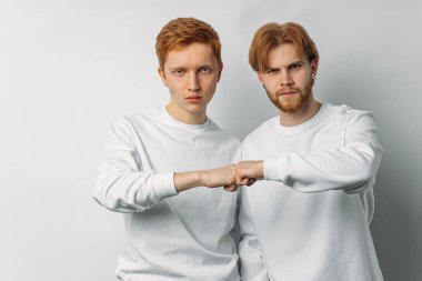 two serious redhead brothers isolated over white background