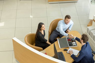 top view on client and agent of dealership shaking hands