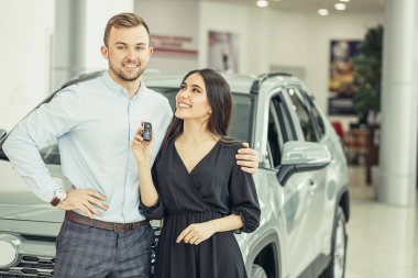 new owners of beautiful car in showroom