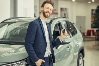 happy caucasian guy after getting keys from new car