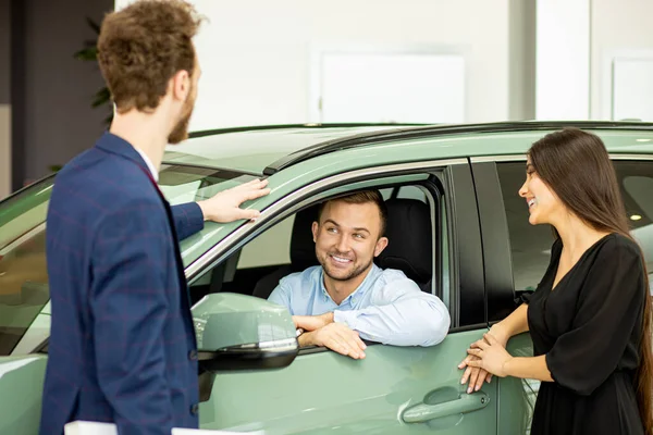 Consultor ayuda a los clientes a elegir un coche nuevo — Foto de Stock