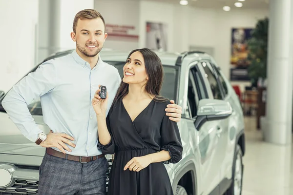 New owners of beautiful car in showroom — Stockfoto