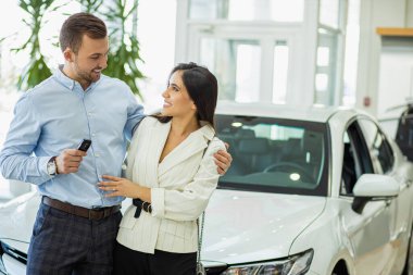 portrait of married couple in car showroom