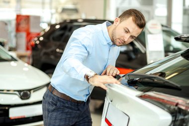 serious customer of car examining new car