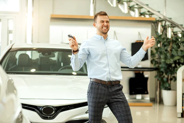 Homem sorrindo positivo feliz após a compra bem sucedida do carro — Fotografia de Stock