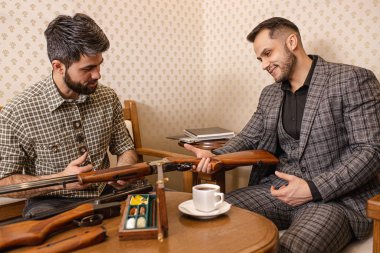 Genç pazarlamacı müşteriye silah seçmesinde yardımcı oluyor.
