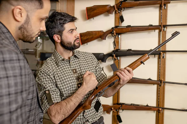Cliente e vendedor discutir poder rifle — Fotografia de Stock