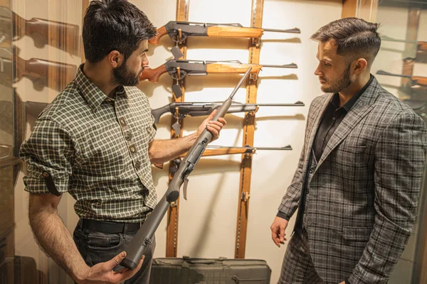 Cliente y vendedor discuten el poder del rifle — Foto de Stock