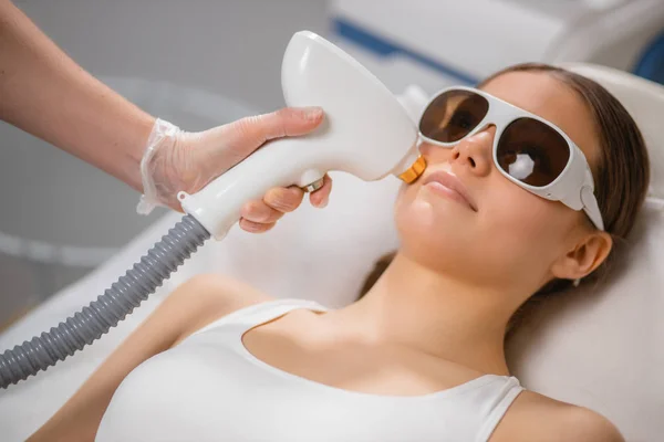 Young woman receiving laser epilation treatment on face at beauty salon — 스톡 사진