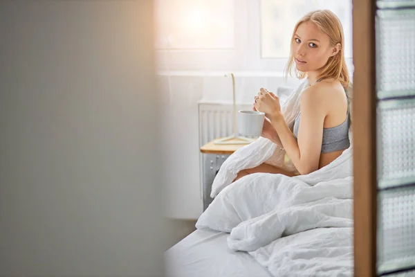 Attractive lady drinking tea on bed in the morning — 스톡 사진